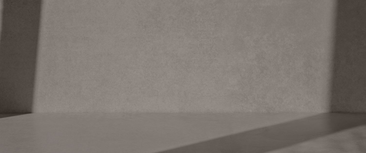 Minimalist gray wall and floor with shadows.